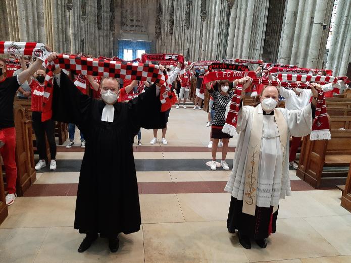 Am Ende der FC-Andacht erklingt die FC-Hymne und alle Schals kreisen. Auch die von Stadtsuperintendent Dr. Bernhard Seiger (li.) und Stadtdechant Msgr. Robert Kleine. Foto: © Johannes Schröer / DOMRADIO.DE (Archiv)