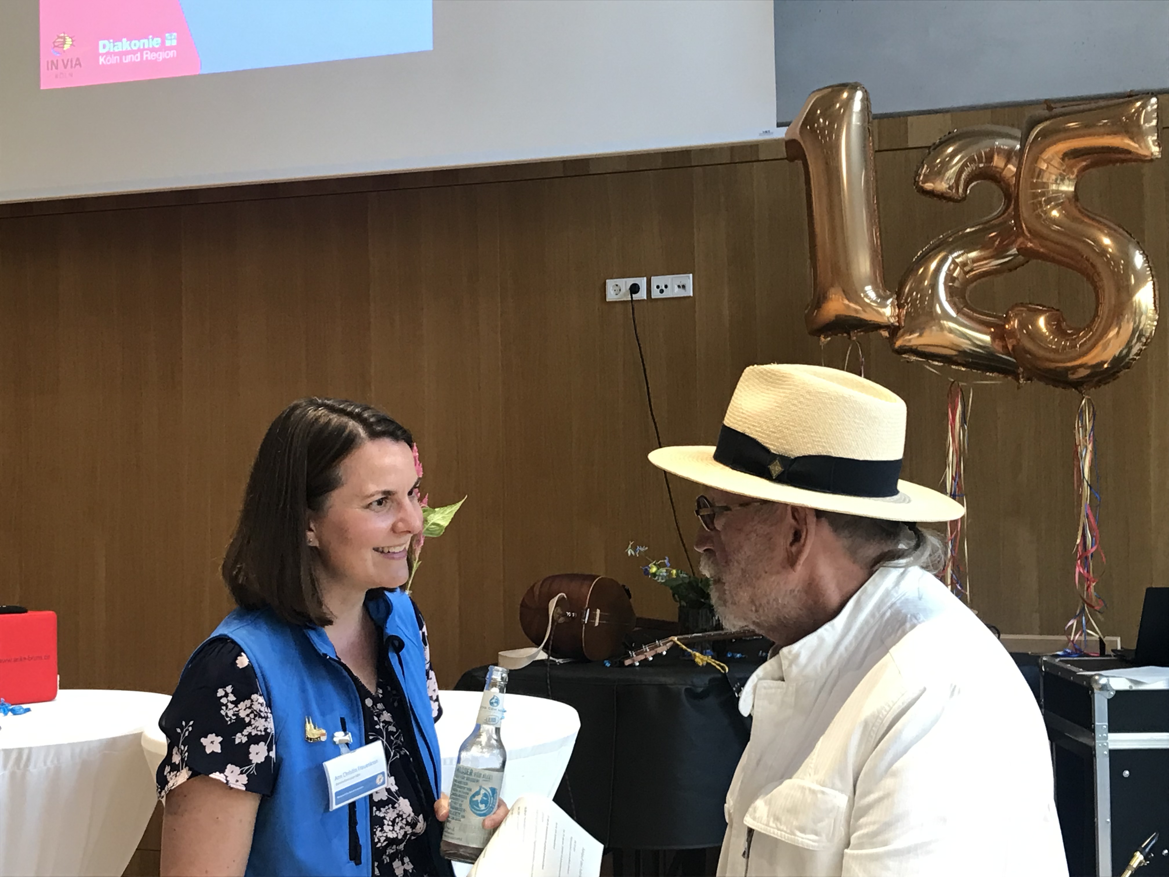 „Ruhestands-Hohn“ Janus Fröhlich im Gespräch mit Ann-Christin Frauenkron. Der Musiker ist der Bahnhofsmission schon lange verbunden und spielte mit in der Jubiläumsband. Foto: © Hildegard Mathies/Stadtdekanat Köln