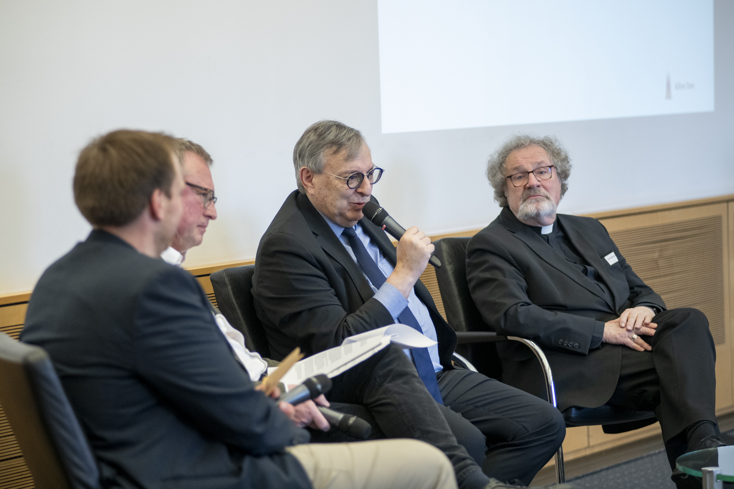 Dr. Abraham Lehrer (2.v.re.), Vizepräsident des Zentralrats der Juden in Deutschland und Vorstand der Synagogen-Gemeinde Köln, gemeinsam mit Weihbischof Rolf Steinhäuser (re.) auf dem Podium des Kolloquiums zum Kunstwettbewerb. Foto: © Hohe Domkirche Köln / Jennifer Rumbach