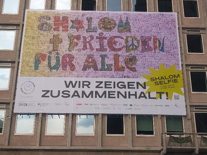 Mit einem XXL-Mosaik am DOMFORUM werben viele Institutionen, darunter die evangelische und die katholische Kirche, für Frieden und Zusammenhalt. Foto: © Hildegard Mathies / Stadtdekanat Köln