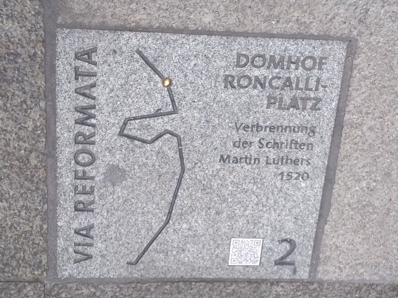 Die Bodenplatte zur Erinnerung an die Verbrennung der Werke von Martin Luther auf dem Kölner Roncalliplatz. Foto: Hildegard Mathies/Stadtdekanat Köln