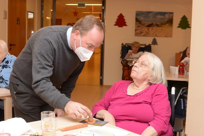 Stadtdechant Robert Kleine mit einer Bewohnerin des Marie-Juchacz-Altenzentrums. Foto: © Beatrice Tomasetti