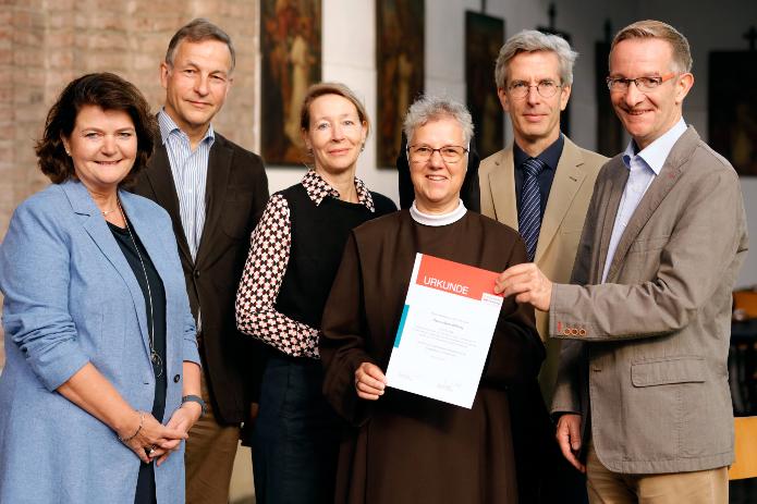 Übergabe der Stiftungsurkunde (v.li.:) : Barbara Lindfeld, Vorstandsmitglied CaritasStiftung im Erzbistum Köln; Rudger von Plettenberg, Geschäftsführer Gesamtverband der katholischen Kirchengemeinden der Stadt Köln; Dr. Kirsten Lange-Wittmann, Stifterin; Sr. Christina Klein OSF, Katholische Wohnungslosenseelsorge „Gubbio“ im Stadtdekanat Köln; Dr. Philipp Wittmann, Stifter; Thomas Hoyer, Vorstandsvorsitzender CaritasStiftung im Erzbistum Köln. Foto: © Jo Schwartz Photographie für „Pace e Bene-Stiftung“.