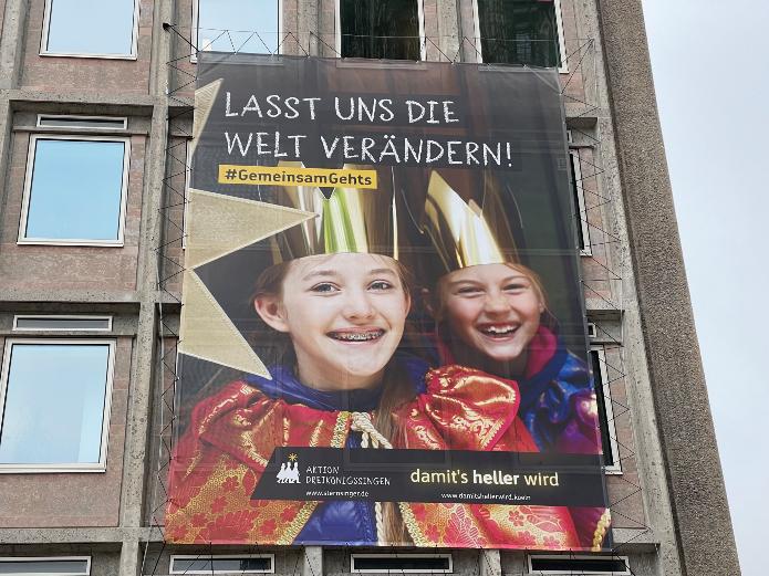 Per Großplakat grüßen Sternsinger vom DOMFORUM und rufen auch 2022/2023 zu Solidarität mit Kindern und Jugendlichen weltweit auf. Foto: © Roman Pojda / DOMFORUM